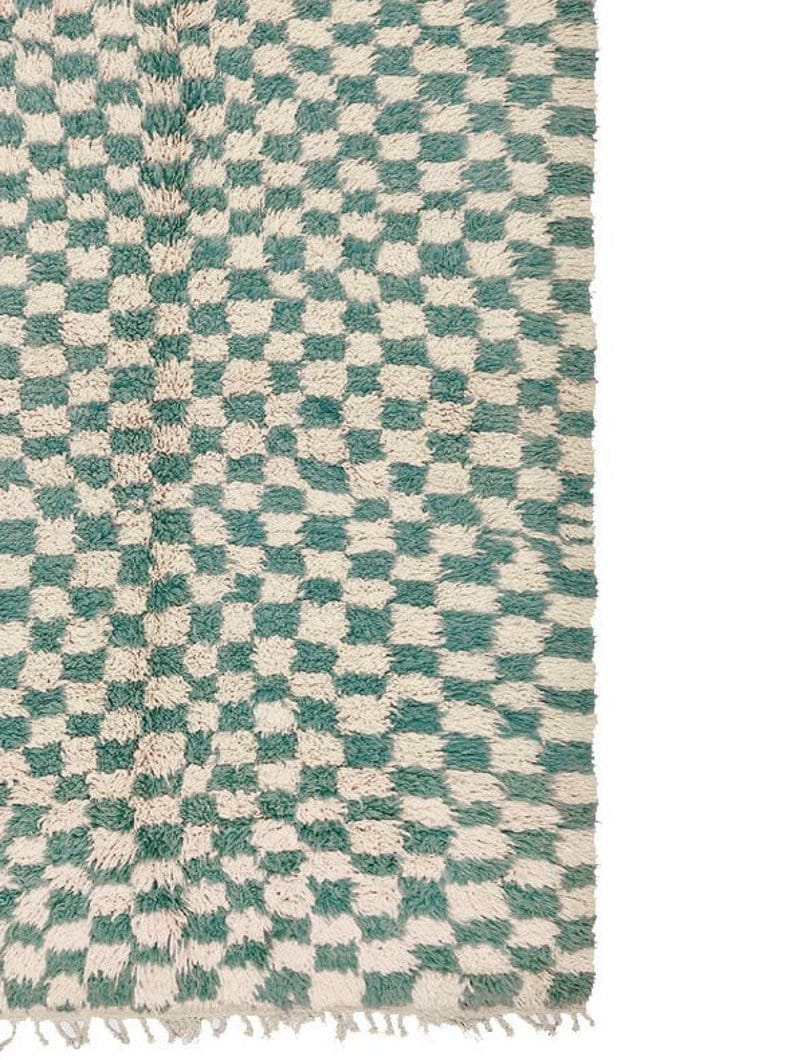 Close-up detail of the green checkered rug emphasizing its unique tribal pattern.