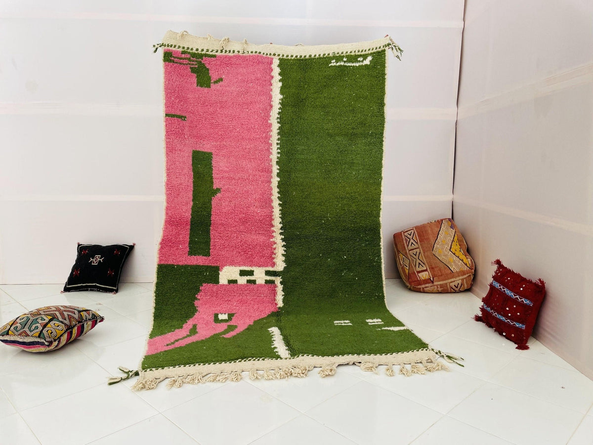 Lifestyle shot of a green and pink vintage Moroccan rug on a white background.