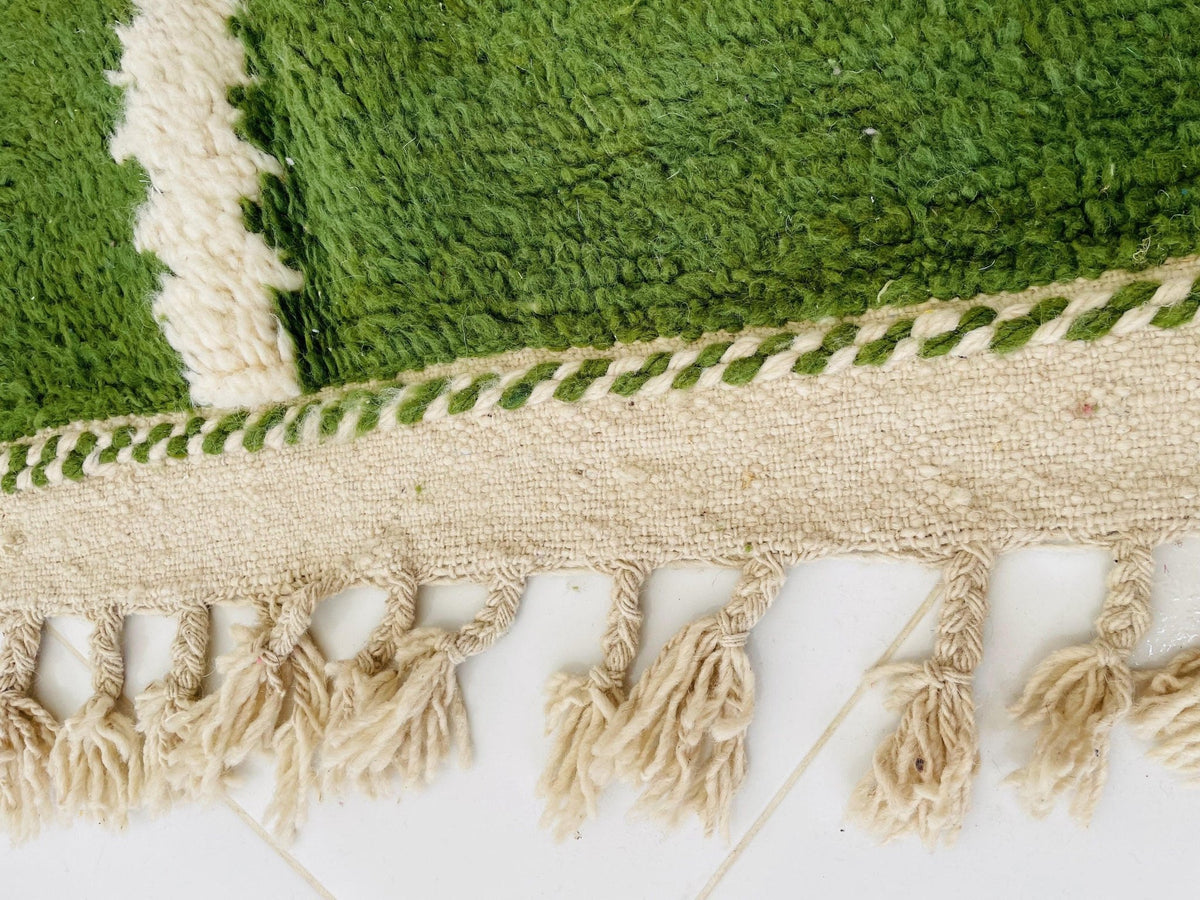 Detail close-up of woven pattern on a green and pink vintage Moroccan rug.