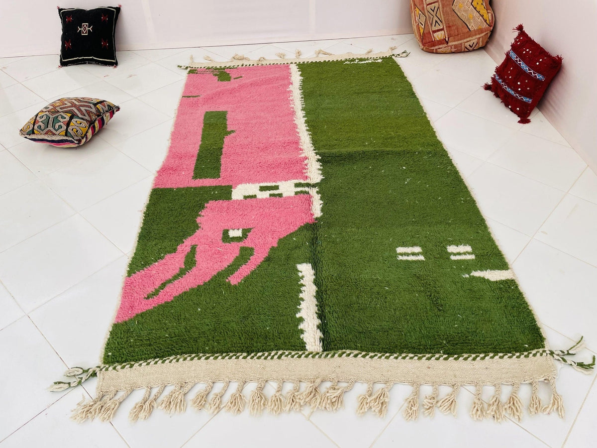 Detail close-up showing fringe edges of a green and pink vintage Moroccan rug.