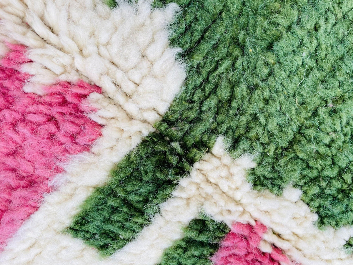 Close-up detail of an intricate design and soft texture on a pink Moroccan rug.
