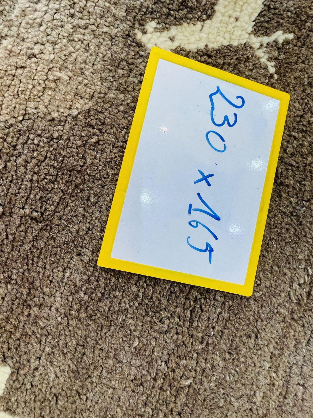 Detail view of a grey Moroccan rug with a label present.