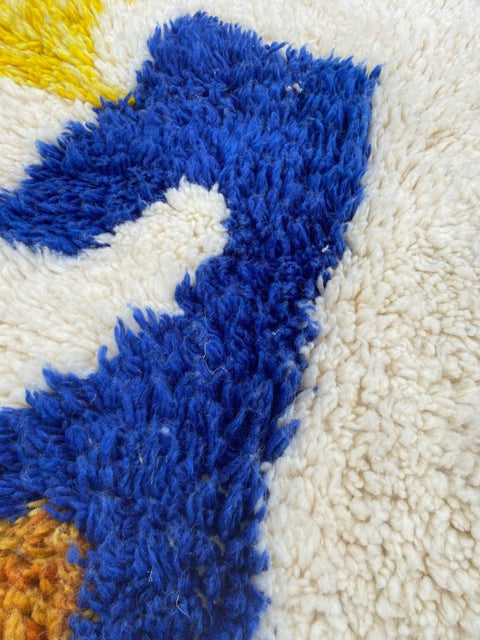 Close-up detail of the textured surface and colorful fibers of a handwoven rug.