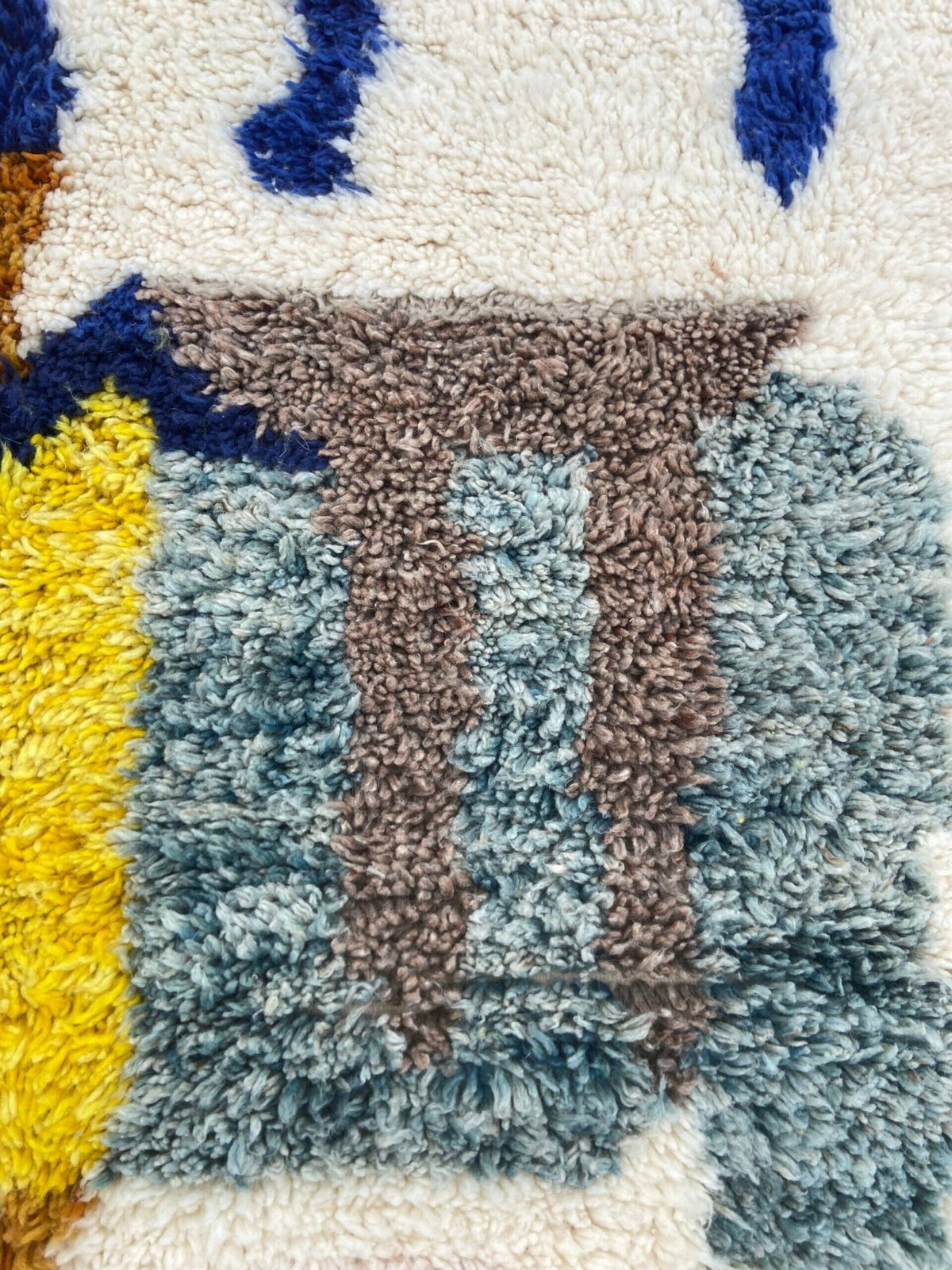 Close-up detail of a handwoven rug displaying a textured pattern and colorful design.
