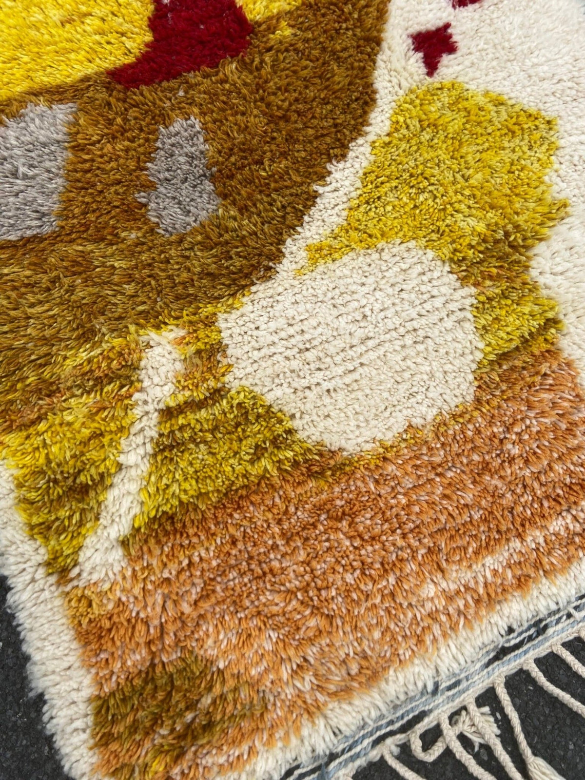 Front view of a handwoven multicolor rug showcasing its abstract pattern and fringe edges.