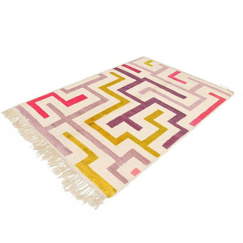 Lifestyle view of the Moroccan rug with fringe edges, highlighting its purple, mustard, and pink colors.