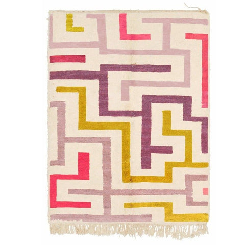 Detail view of the geometric pattern in purple, mustard, and pink on a Moroccan rug.