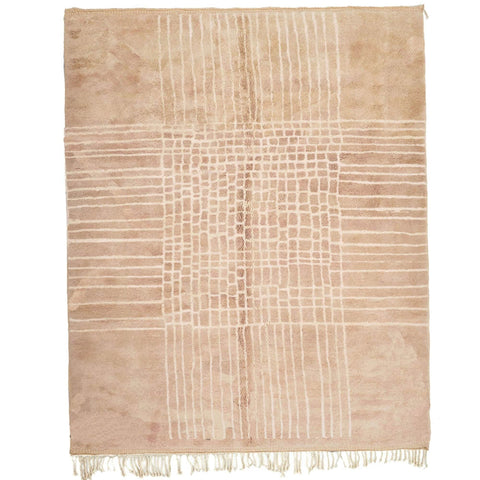 Detail close-up of a neutral Moroccan rug showcasing woven texture and fringe edges.