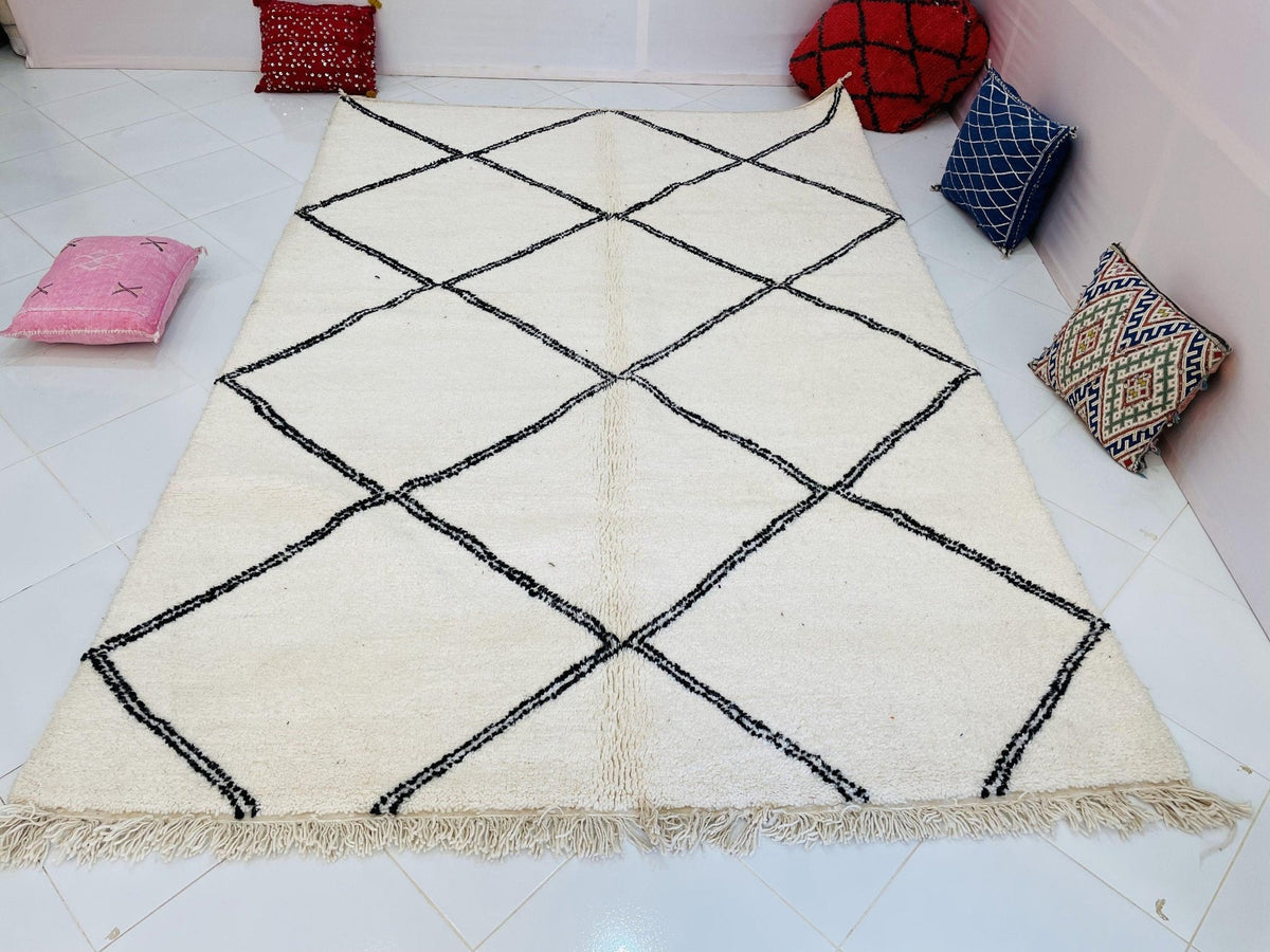 Lifestyle shot of a Moroccan rug showcasing a diamond pattern with a white and black color scheme.