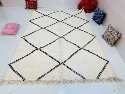 Lifestyle shot of a Moroccan rug showcasing a diamond pattern with a white and black color scheme.