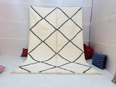Lifestyle shot of a Moroccan rug featuring a diamond pattern in white and black.