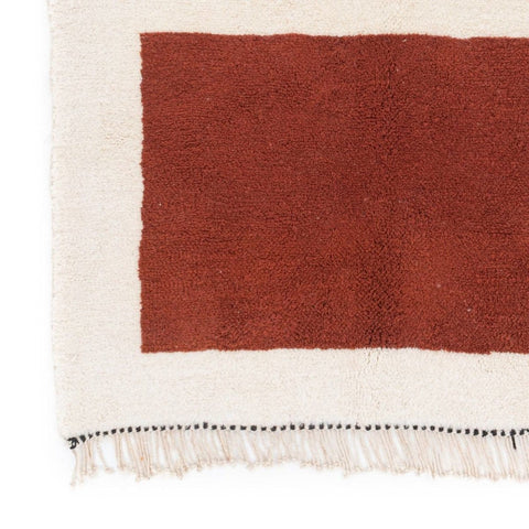 Close-up detail of the cream and burgundy color block Moroccan rug with geometric pattern.