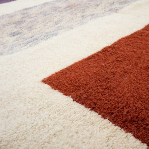 Detail view of the cream and burgundy color block Moroccan rug featuring geometric patterns.