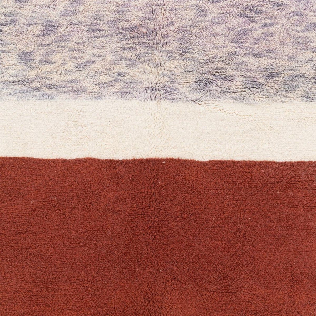 Close-up detail of the cream and burgundy color block Moroccan rug highlighting its textured surface.