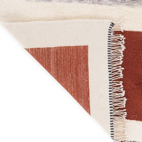 Detail shot of the cream and burgundy color block Moroccan rug showcasing fringe detail.
