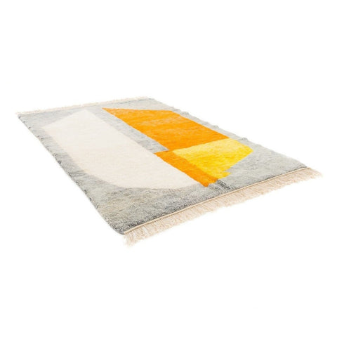Packaging shot of the rolled gray and orange color block rug with label visible.