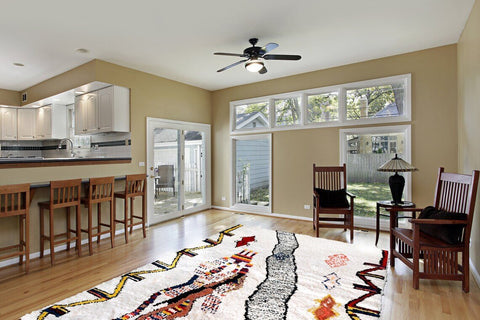 Lifestyle shot of a spacious living room featuring the multicolor abstract Azilal Moroccan rug with natural light.