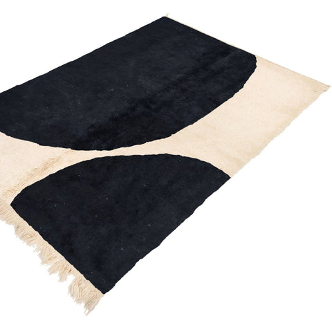 Close-up of the textured surface of a black and white Moroccan Beni Ourain rug.