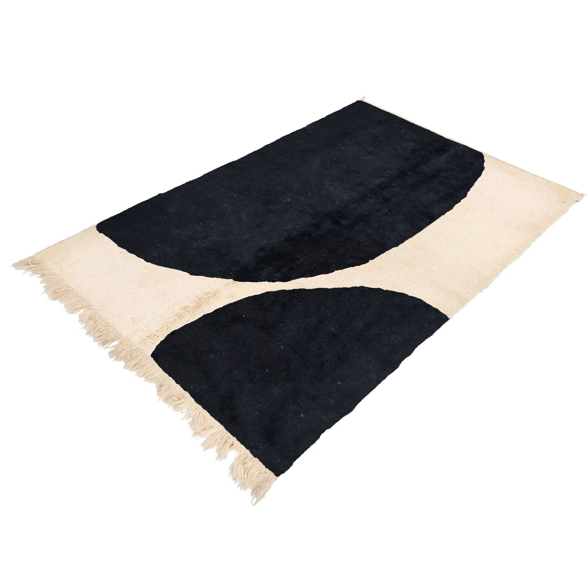 Side view of a black and white Moroccan Beni Ourain rug showcasing curved shapes.
