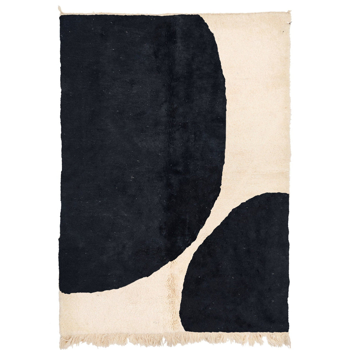 Detail view of a black and white Moroccan Beni Ourain rug featuring geometric patterns and fringe edges.