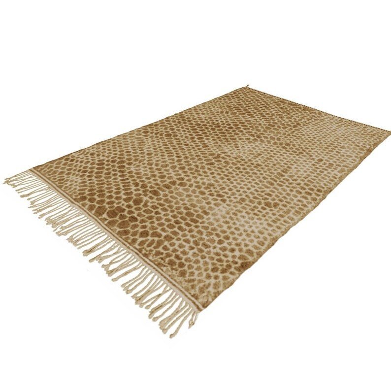 Lifestyle shot of a brown berber rug with fringe edges in a natural setting.
