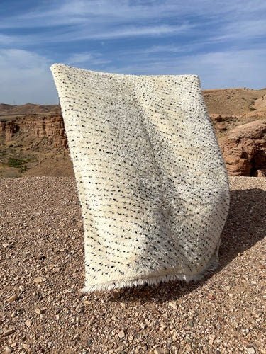 Side view of the gray and cream Moroccan Beni Ourain rug showcasing its textured surface.