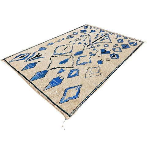 Side view of a blue Berber rug showcasing geometric patterns and fringe edges.