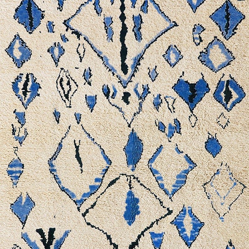 Side view of a blue Berber rug highlighting geometric patterns and fringe edges.