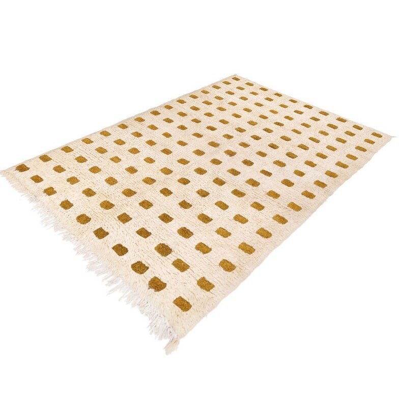 Side view of the beige checkered Moroccan rug featuring fringed edges.