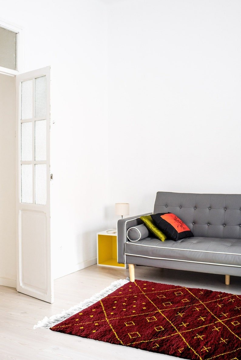 Close-up of the red Beni Ourain rug showcasing geometric designs against a white backdrop.