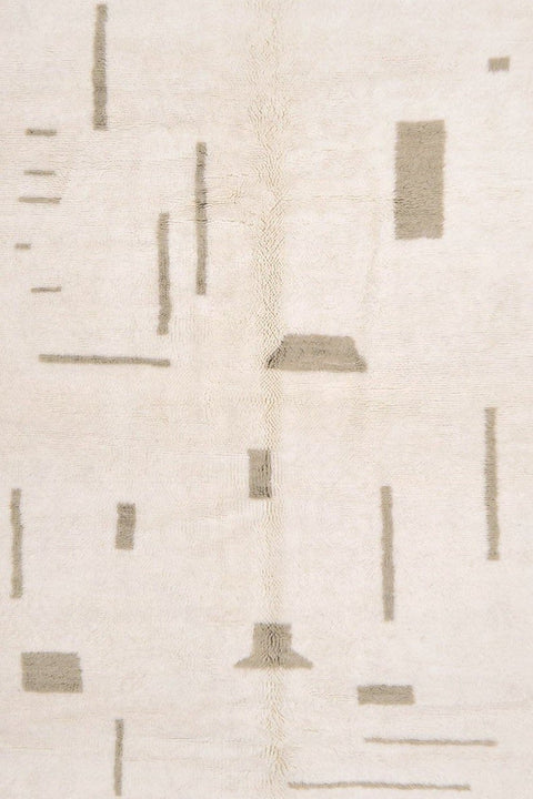 Close-up of an off-white gray Moroccan rug featuring a geometric design and soft texture.