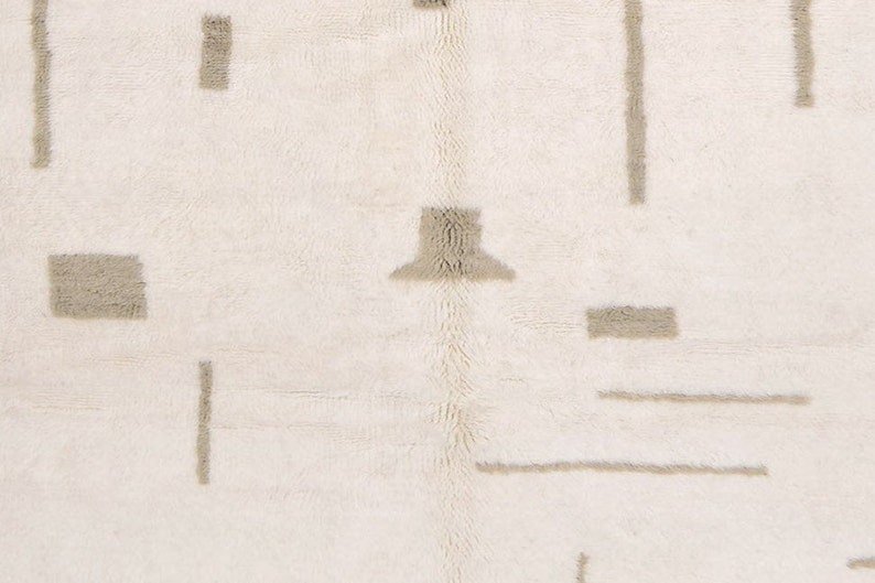 Front view of an off-white gray Moroccan rug showcasing geometric patterns and fringe edges.