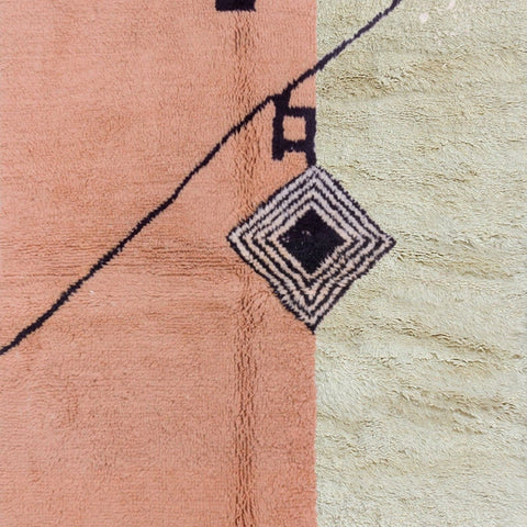 Side view of the pink geometric pattern rug showcasing its fringe edges.