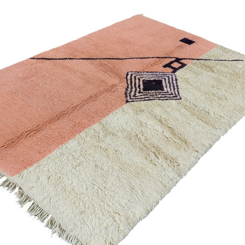 Lifestyle view of the pink design rug featuring geometric patterns and fringe edges.