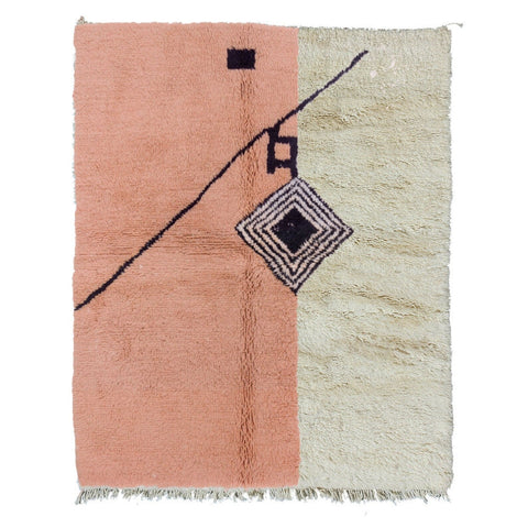 Detail shot of the pink geometric pattern rug with fringe edges.