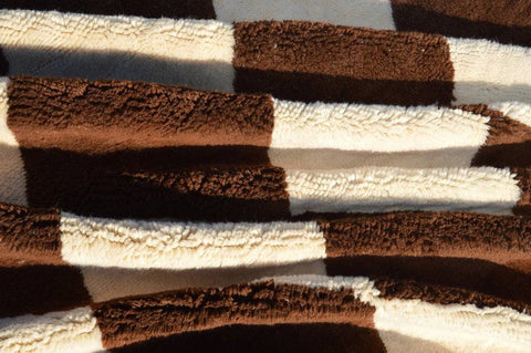 Close-up detail of the brown and cream diamond pattern on the Moroccan rug.