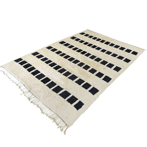 Close-up detail of the woven texture on the black and white striped Moroccan rug.