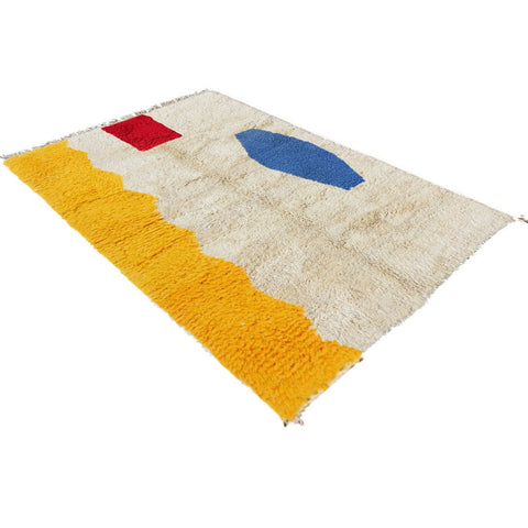 Side view of a multicolor abstract Moroccan rug showcasing its geometric patterns in beige, red, blue, and yellow.