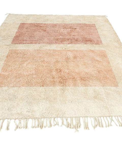 Detail close-up of a beige and pink geometric abstract rug on a white background
