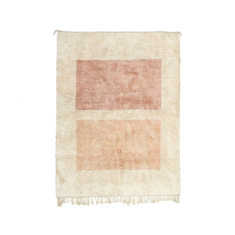 Detail close-up of a beige and pink geometric abstract rug on a white background