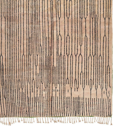 Detail close-up of the black and white Moroccan rug highlighting fringe edges and Berber design.