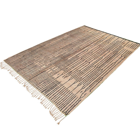 Lifestyle shot of the black and white Moroccan rug in a room setting, displaying fringe edges and Berber design.