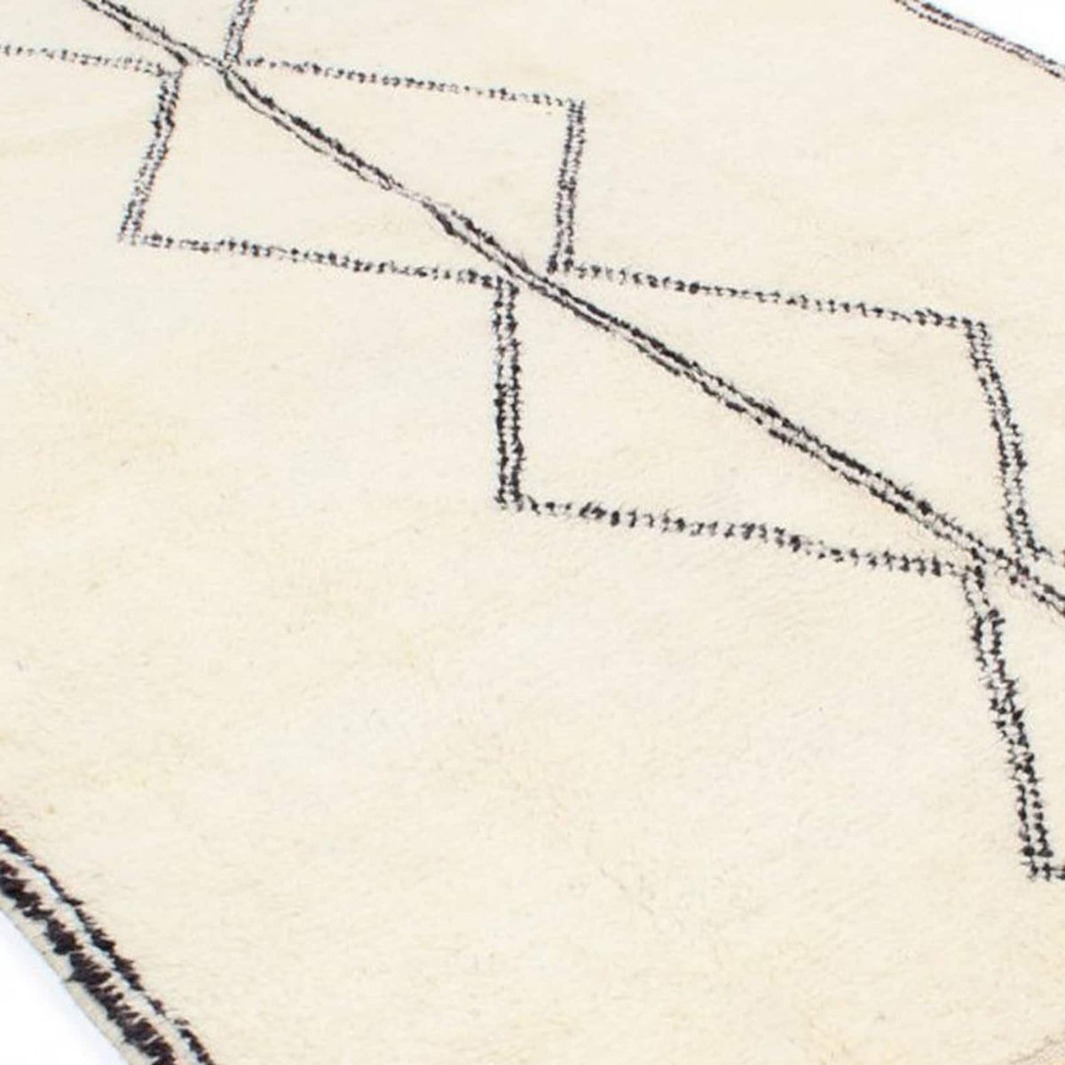 Close-up detail of the black and white Moroccan rug highlighting the geometric pattern.