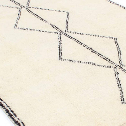 Close-up detail of the black and white Moroccan rug highlighting the geometric pattern.
