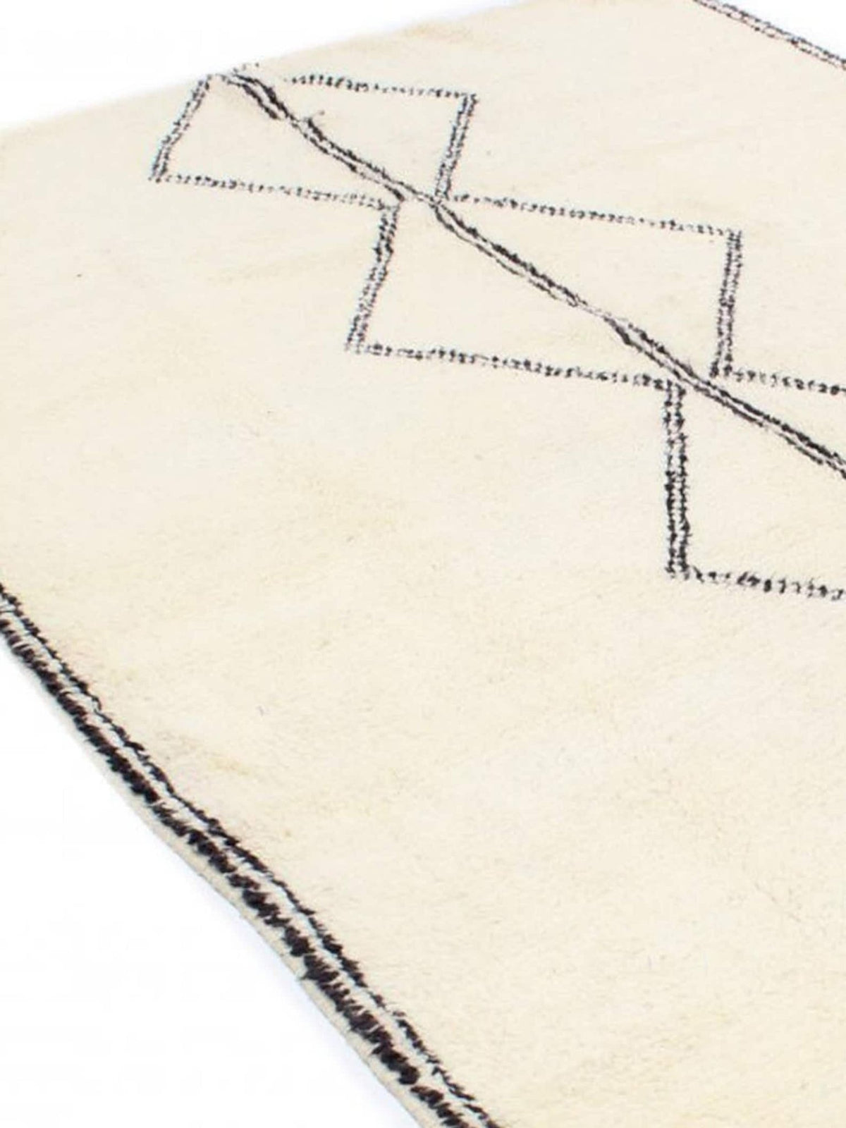 Close-up detail of the black and white Moroccan rug with a focus on its geometric features.