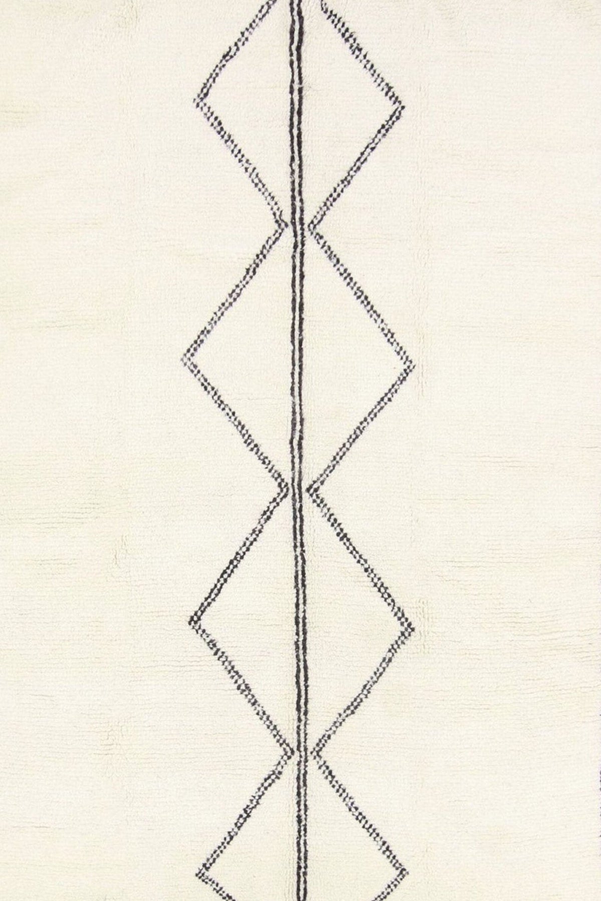 Close-up detail of the black and white Moroccan rug showcasing its geometric design.