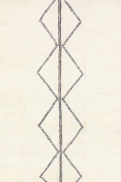 Close-up detail of the black and white Moroccan rug showcasing its geometric design.