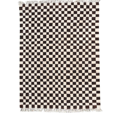 Detail close-up of the black and white checkered pattern on the Moroccan rug.
