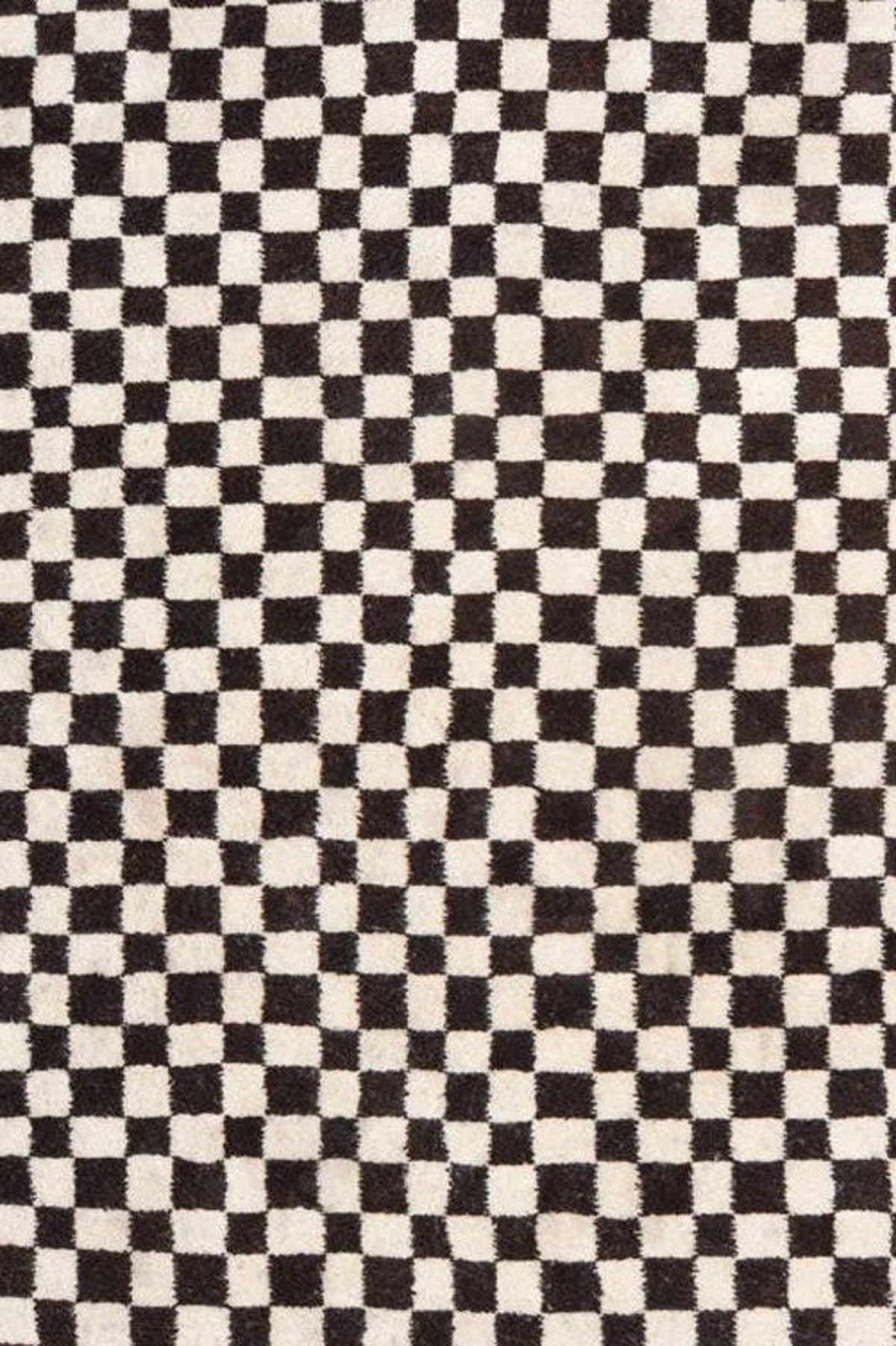 Detail close-up of the checkered pattern and fringe on the Moroccan rug.