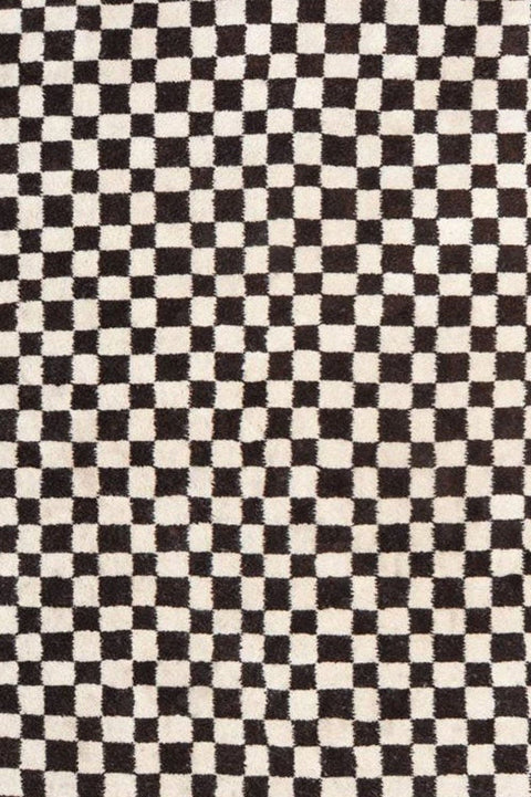 Detail close-up of the checkered pattern and fringe on the Moroccan rug.